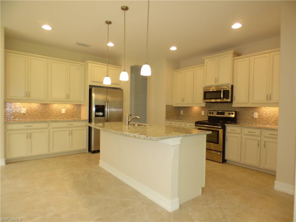 16325 Aberdeen Way Naples, FL 34110 - Photo 10 of 24 a kitchen with stainless steel appliances granite countertop a stove a sink and a refrigerator