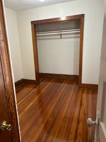an empty room with wooden floor and closet
