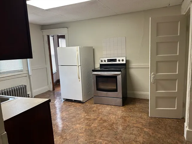 a kitchen with a refrigerator sink and cabinets