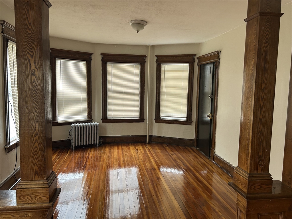 448 Dickinson Street, Unit 1R Springfield, MA 01108 - Photo 8 of 8 a view of empty room with wooden floor and fan