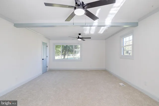 a view of an empty room with a ceiling fan