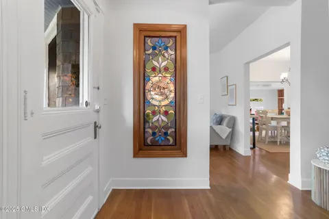 a living room with furniture a rug potted plant and a window
