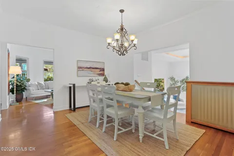 a living room with stainless steel appliances furniture a rug and a kitchen view