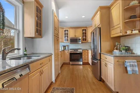 a kitchen with a sink a stove cabinets and a window