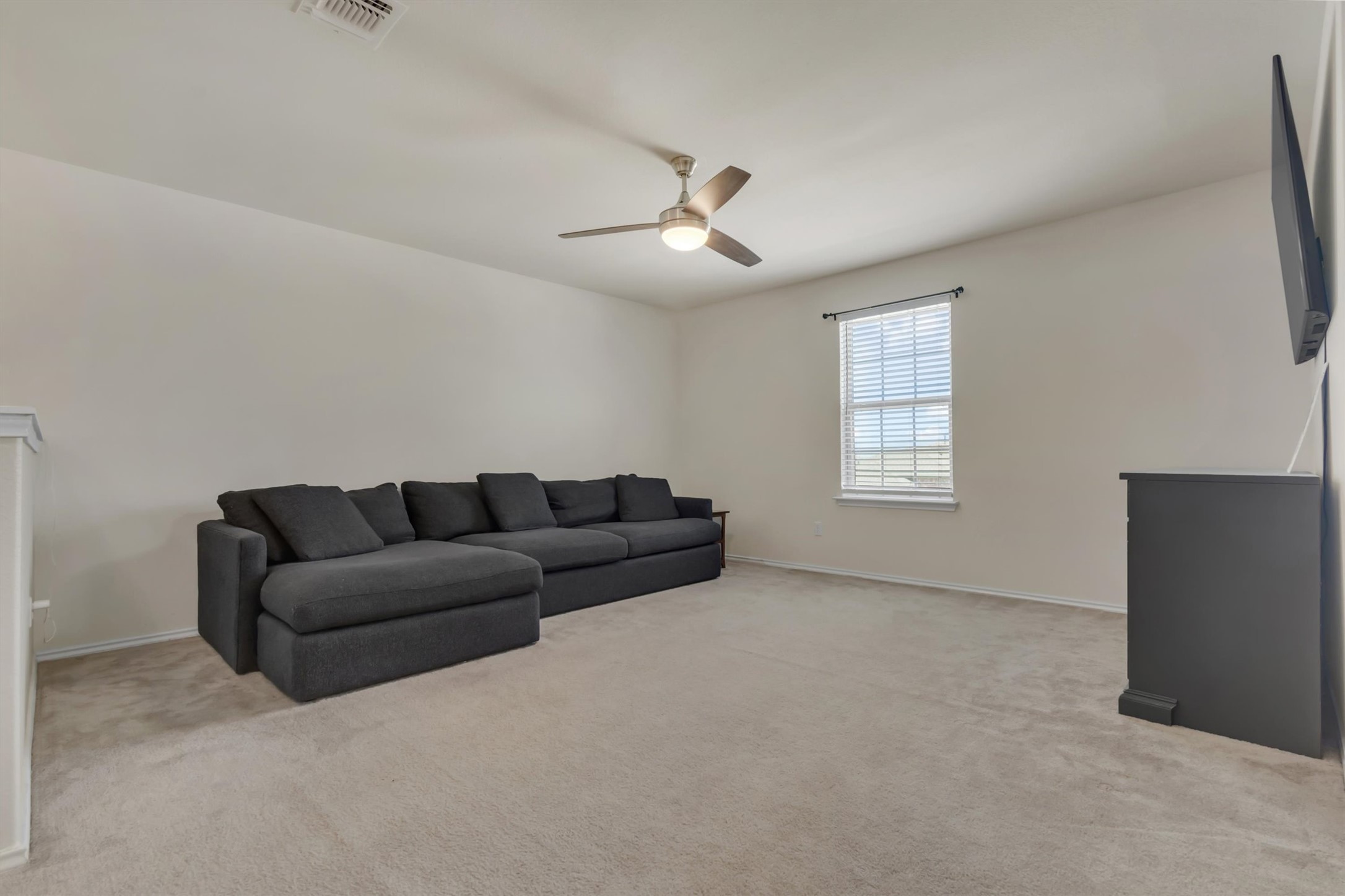 11701 Jackson Falls Way Manor, TX 78653 - Photo 26 of 40 An inviting secondary living space, perfect for quiet evenings or casual gatherings, features soft carpeting and a ceiling fan for comfort.