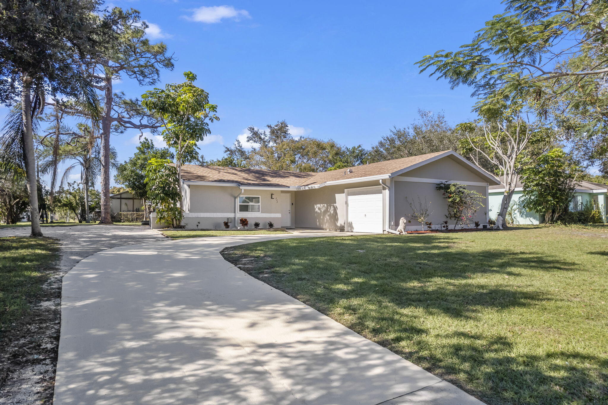 333 Southwest Kentwood Road Port St. Lucie, FL 34953 - Photo 1 of 22 a front view of a house with a garden