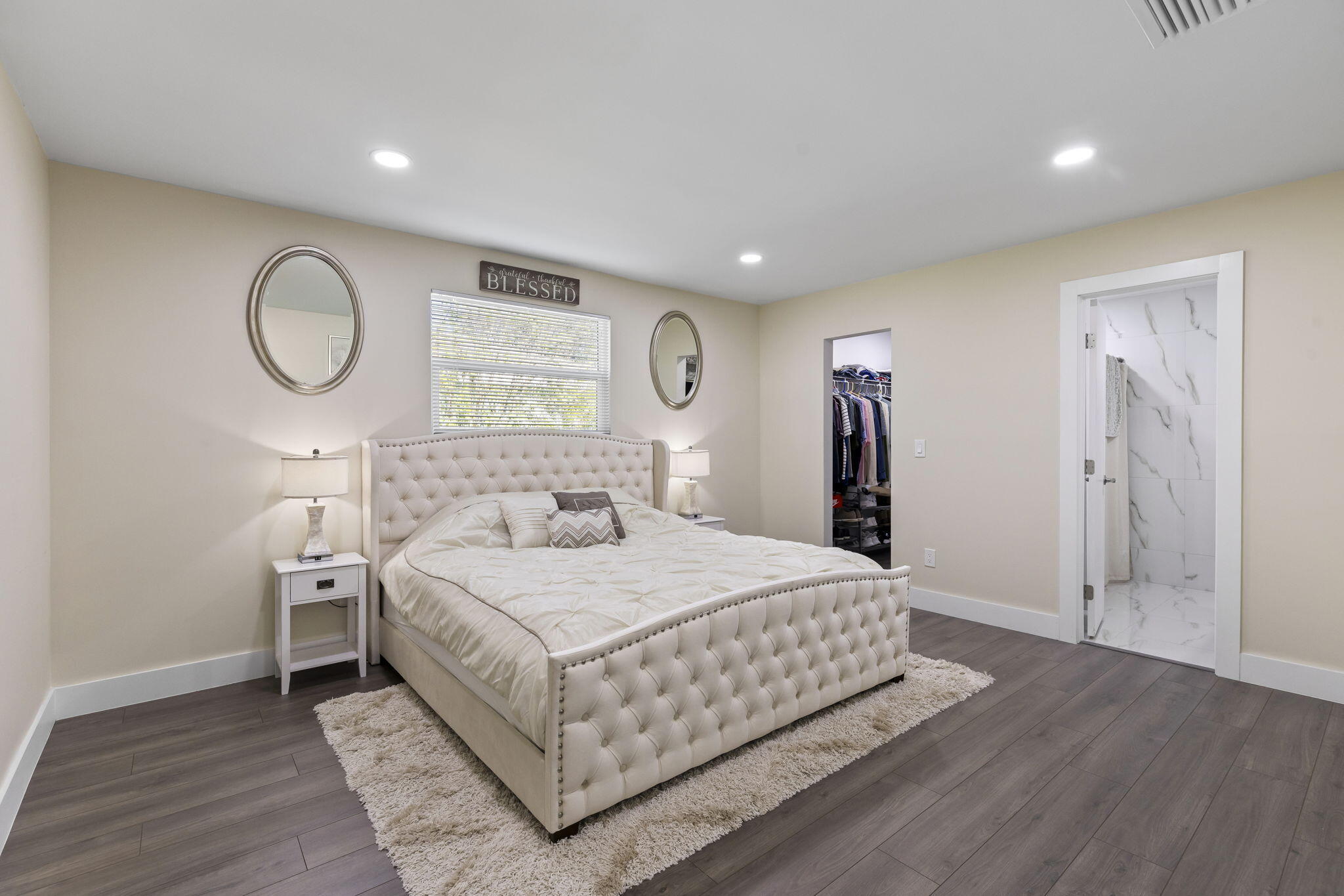 333 Southwest Kentwood Road Port St. Lucie, FL 34953 - Photo 8 of 22 a bedroom with a large bed and a chandelier
