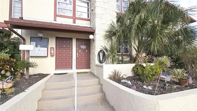 a view of a house with a yard and potted plants