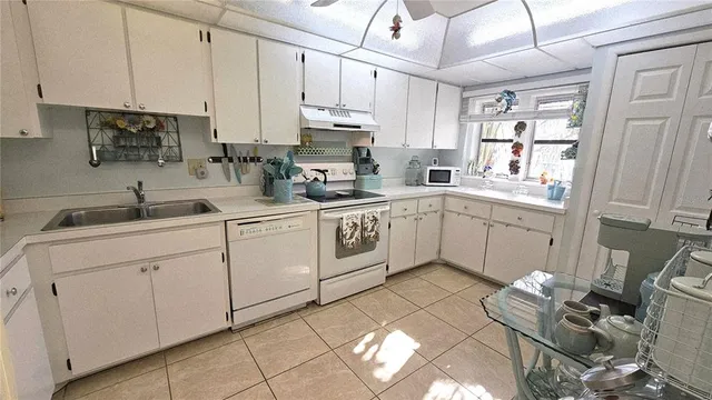 a kitchen with cabinets appliances a sink and a counter top space