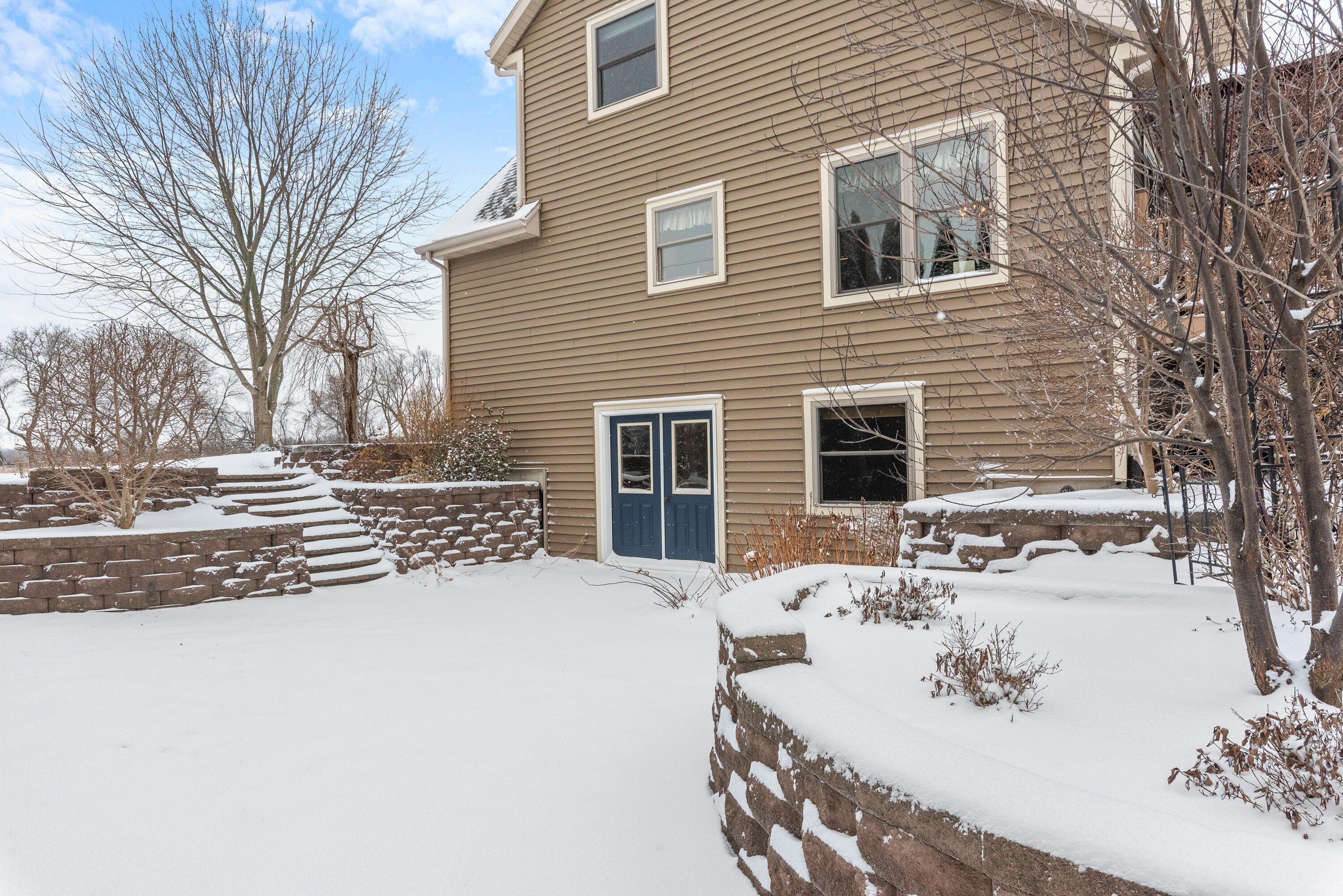 W1072 Hilltop Road Rubicon, WI 53078 - Photo 42 of 51 This is the side view with the walk out lower level. Nicely built retaining walls & steps.