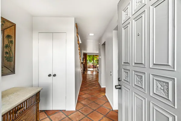 a view of a hallway with a livingroom and furniture