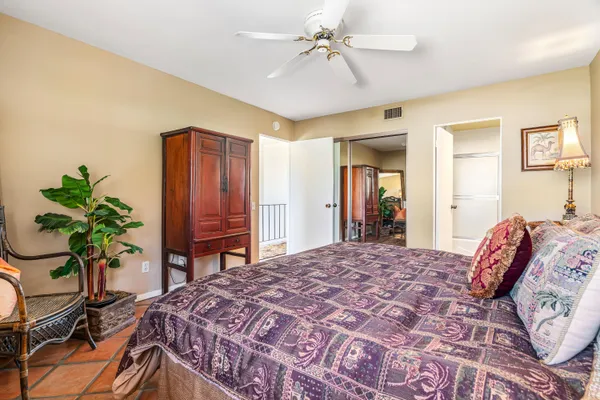 a bedroom with a bed and a potted plant