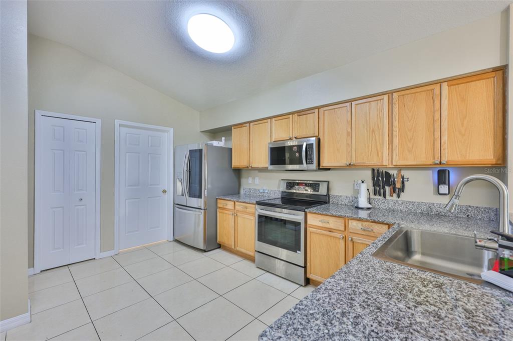 2613 Thames River Place Valrico, FL 33596 - Photo 17 of 41 a kitchen with stainless steel appliances granite countertop a stove top oven a sink a refrigerator and white cabinets