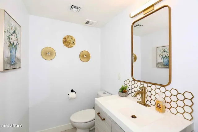 a bathroom with a sink mirror and toilet