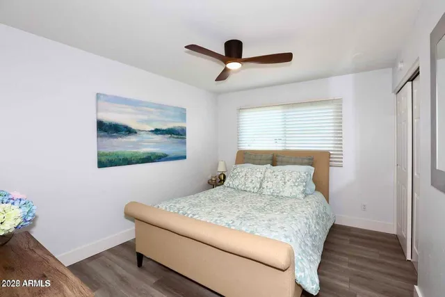 a bedroom with a bed and a painting on the wall