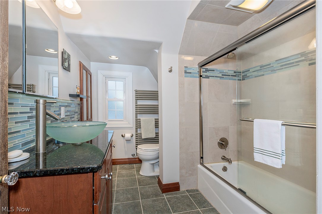 3259 Avalon Road Cleveland, OH 44120 - Photo 16 of 31 Bathroom with enclosed tub / shower combo, radiator, vanity, dark tile patterned flooring, and decorative backsplash