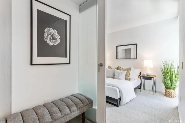 a bedroom with a bed and a painting on the wall