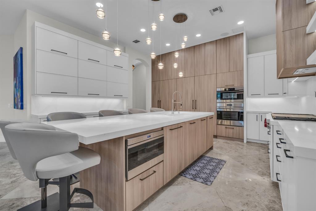 7328 Ballantrae Court Boca Raton, FL 33496 - Photo 8 of 89 a kitchen with kitchen island granite countertop a sink and white cabinets