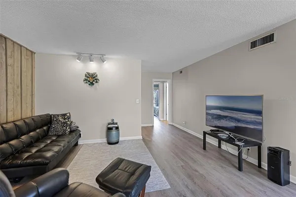 a living room with furniture and a wooden floor