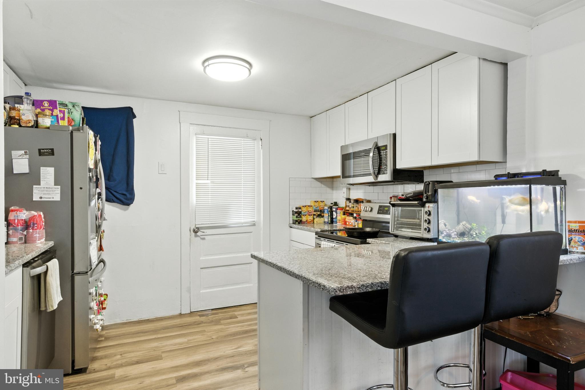 1745 Filbert Street York, PA 17404 - Photo 7 of 26 a kitchen with stainless steel appliances granite countertop a refrigerator a stove a sink dishwasher and a refrigerator with wooden floor