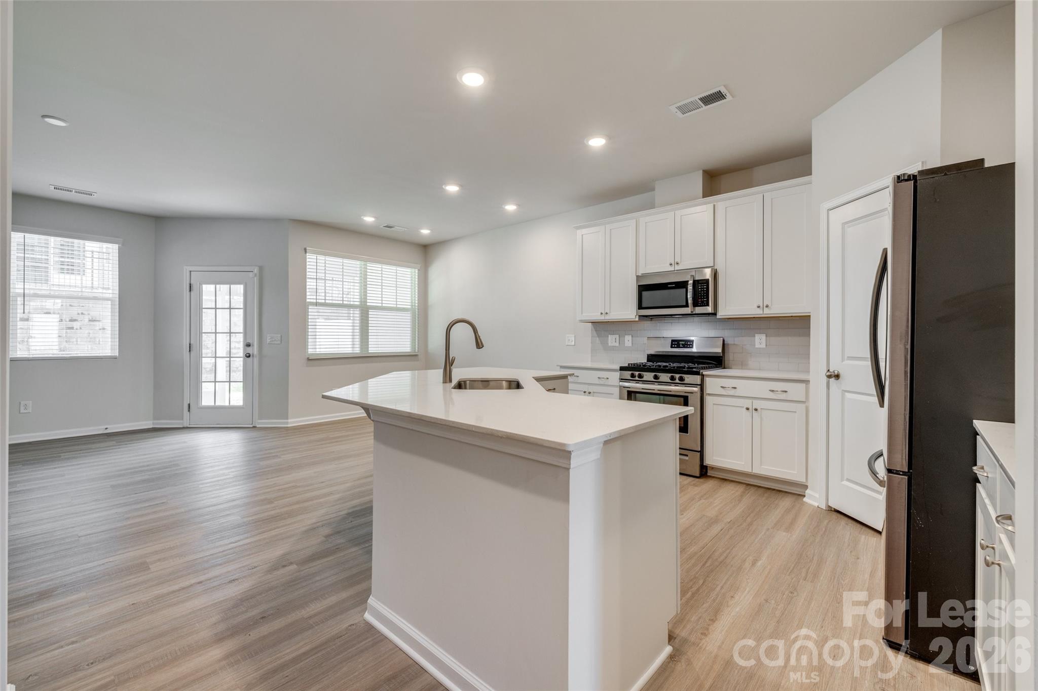 807 Gable Oak Lane Fort Mill, SC 29708 - Photo 4 of 39 a kitchen with kitchen island granite countertop a sink appliances cabinets and a counter top space