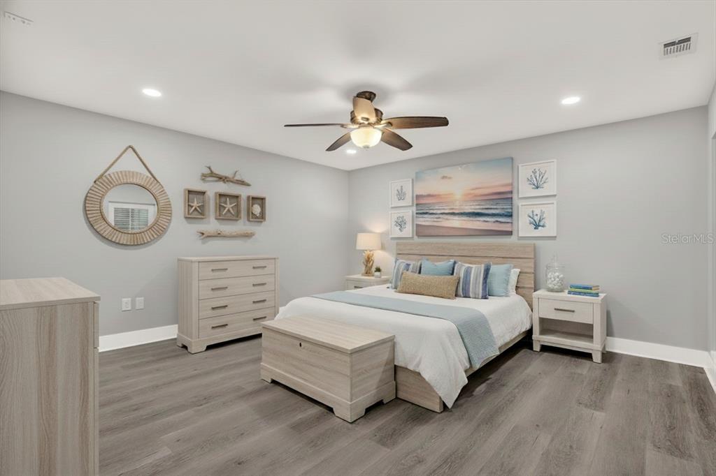 337 Rex Place, Unit A Madeira Beach, FL 33708 - Photo 16 of 48 a bedroom with a bed chandelier and dresser