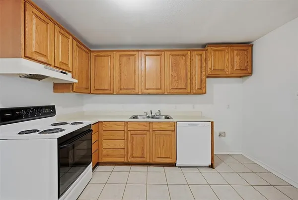 an empty room with wooden floor ceiling fan and windows