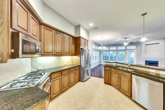 a kitchen with stainless steel appliances granite countertop a stove and a sink