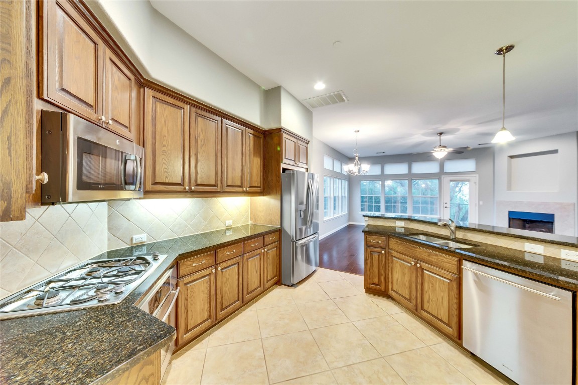 a kitchen with stainless steel appliances granite countertop a stove and a sink