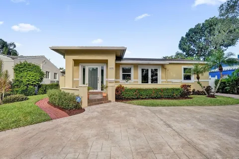 a view of a house with a yard and potted plants