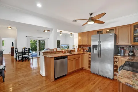 a kitchen with stainless steel appliances granite countertop a stove refrigerator and a sink