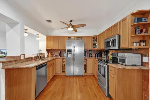 a kitchen with stainless steel appliances granite countertop a refrigerator a sink and dishwasher