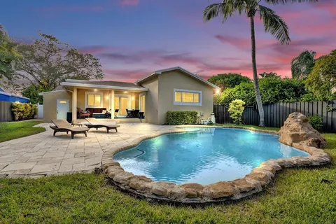 a view of a house with swimming pool and sitting area