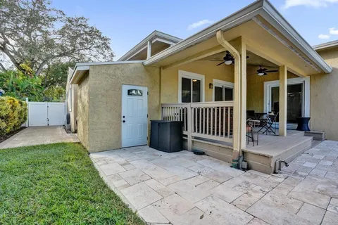 a front view of a house with a yard and potted plants