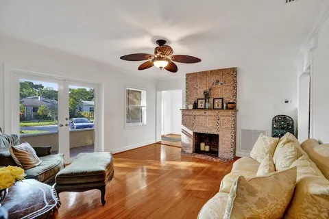 a kitchen with stainless steel appliances granite countertop a refrigerator a stove a sink a dining table and chairs with wooden floor