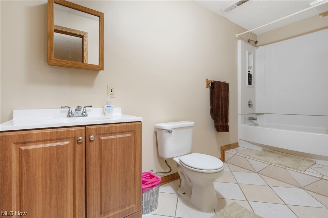 4915 Monticello Street Northwest Canton, OH 44708 - Photo 27 of 31 Full bathroom featuring shower / bathtub combination, vanity, toilet, and tile floors in basement