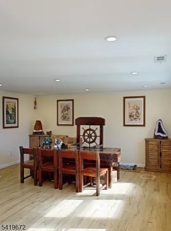 a living room with furniture a piano and a bookshelf