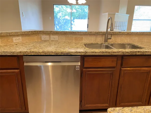 a kitchen with granite countertop cabinets stove top oven and microwave