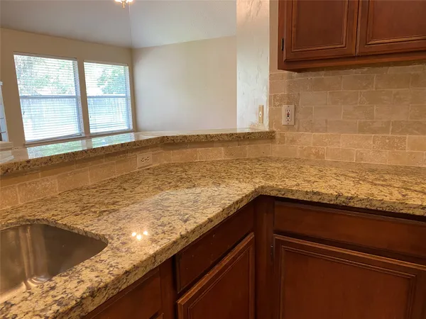 a kitchen with a sink a counter top space cabinets and chandelier