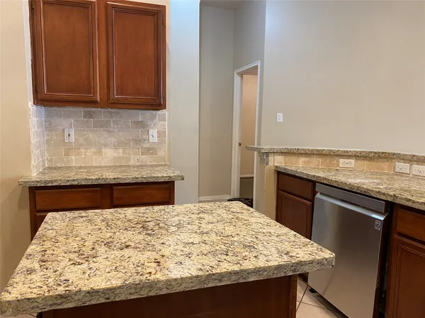 a kitchen with stainless steel appliances granite countertop a sink a refrigerator and a granite counter tops