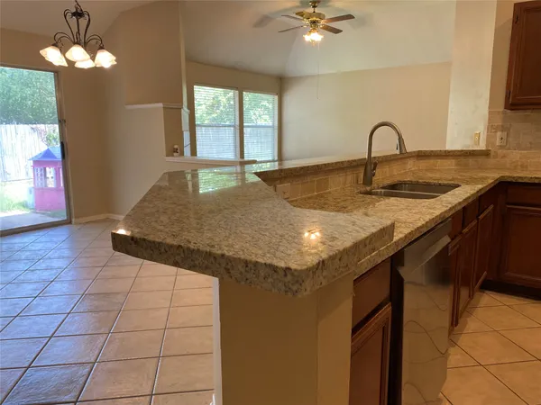 a kitchen with granite countertop cabinets stainless steel appliances and a window