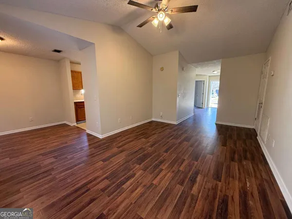 an empty room with wooden floor and windows