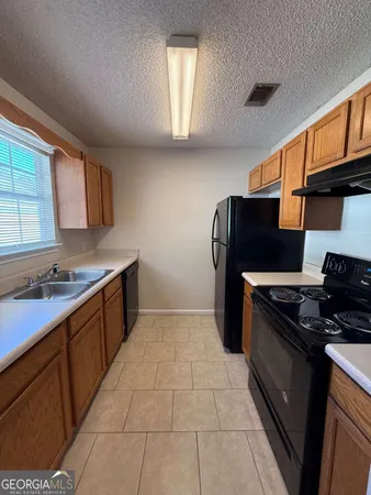 a kitchen with a stove a refrigerator and cabinets