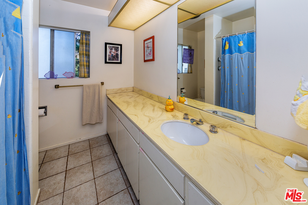 3088 Paddington Road Glendale, CA 91206 - Photo 14 of 17 a bathroom with a granite countertop sink and a mirror