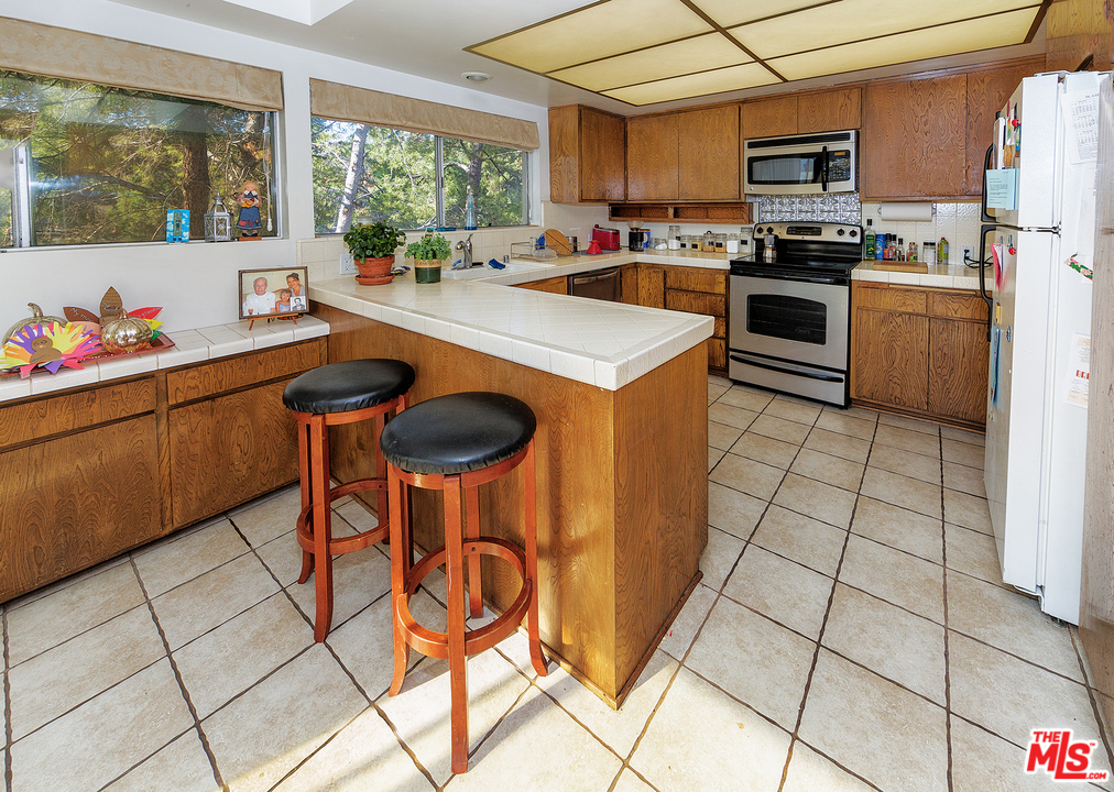 3088 Paddington Road Glendale, CA 91206 - Photo 6 of 17 a kitchen with stainless steel appliances a stove a sink a microwave and a refrigerator