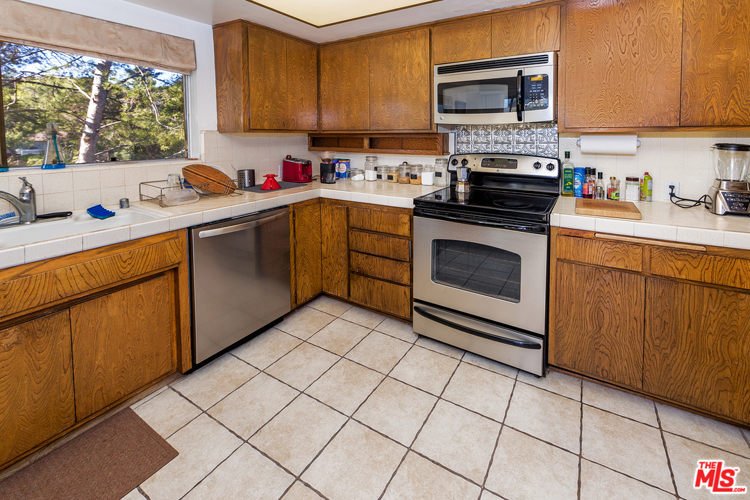 3088 Paddington Road Glendale, CA 91206 - Photo 10 of 17 a kitchen with a sink a stove top oven a counter space and cabinets