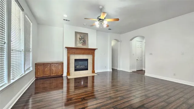 a view of an empty room with a fireplace and wooden floor