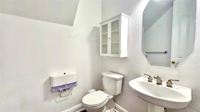 a bathroom with a sink a toilet and a mirror