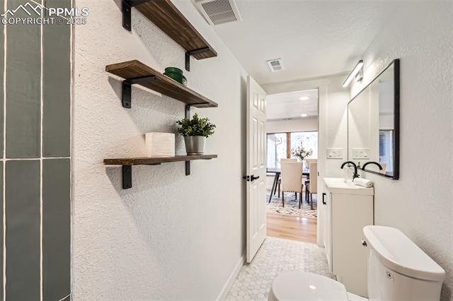 33 Cherokee Road Manitou Springs, CO 80829 - Photo 13 of 37 Bathroom featuring visible vents, toilet, vanity, and a textured wall