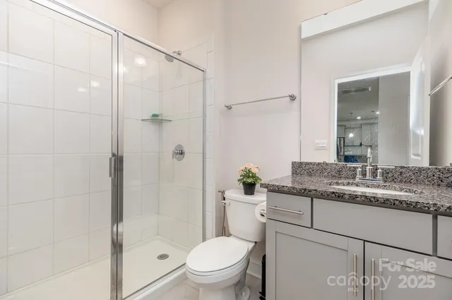 a bathroom with a granite countertop sink toilet and shower